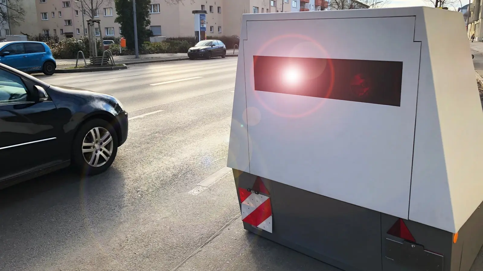 Blitzeranhänger mit Lasertechnologie überwachen verstärkt die Geschwindigkeit Ein Auto wird von einem Blitzeranhänger innerorts geblitzt