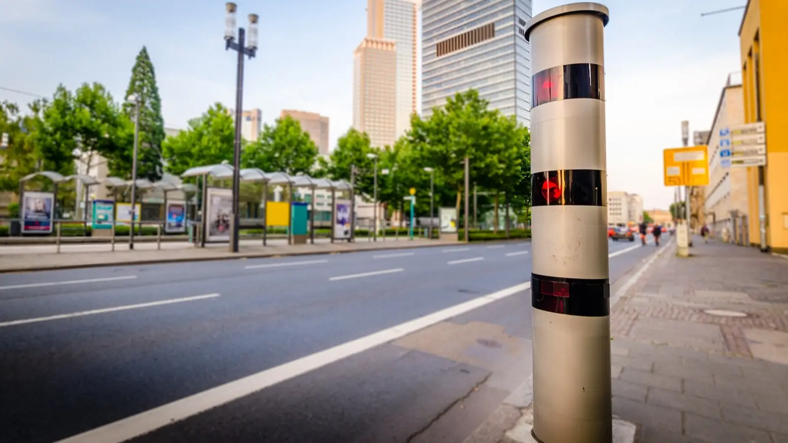 Poliscan Speed gibt es als Blitzersäule und als Laserblitzer auf einem Stativ. Ein moderne Poliscan Speed Blitzersäule mit 3 Laserringen steht in einer deutschen Innenstadt am Straßenran